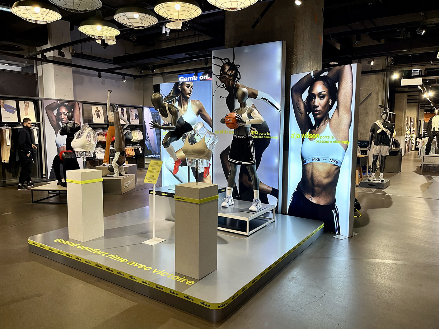 Large-scale display featuring dynamic product presentation and brand storytelling for Nike Bras campaign at Nike La Defense Paris